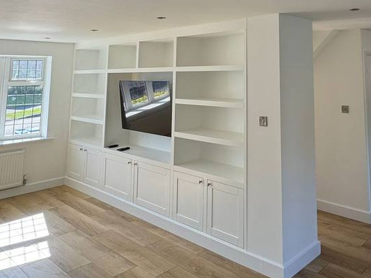 The finished fitted media unit, painted white with shelves and cupboards