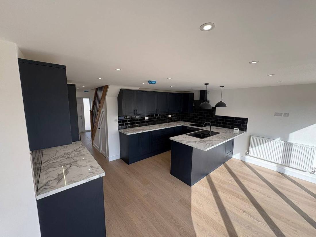 Navy shaker kitchen with marble-effect worktops and island