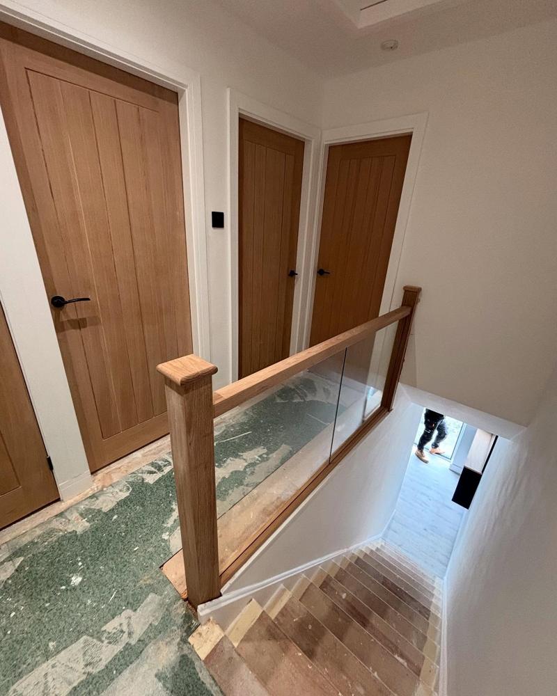 Oak doors and glass balustrade on an upstairs landing