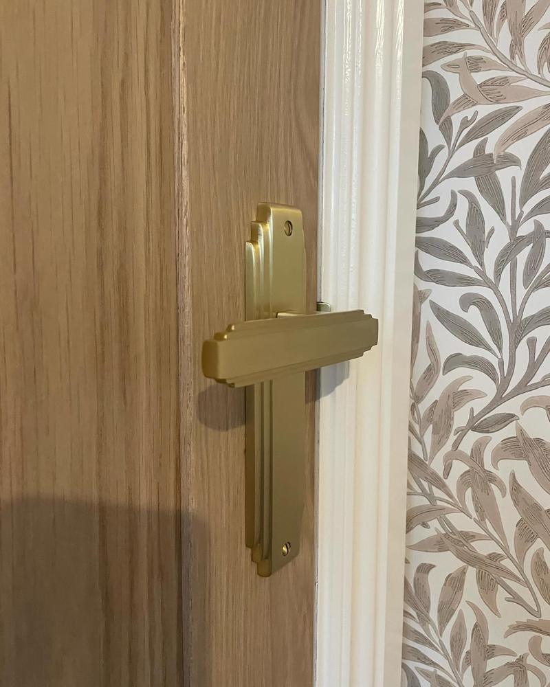 Close-up of a brass lever handle on an oak door